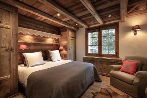 a bedroom with a large bed and a chair at Chalet Ruitor, chalet 500 m2 luxueux de caractère in Sainte-Foy-Tarentaise