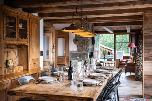 a long wooden table with plates and glasses on it at Chalet Ruitor, chalet 500 m2 luxueux de caractère in Sainte-Foy-Tarentaise