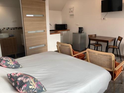 a room with a bed and chairs and a table at Aparthotel Des 2 Caps in Ambleteuse