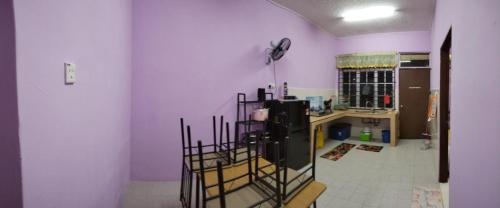 a kitchen with purple walls and a room with a fan at Kak CTi Homestay in Kuala Terengganu