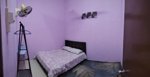 a small room with a bed and a ladder at Kak CTi Homestay in Kuala Terengganu