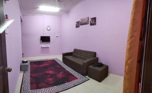 a living room with a couch and a chair at Kak CTi Homestay in Kuala Terengganu