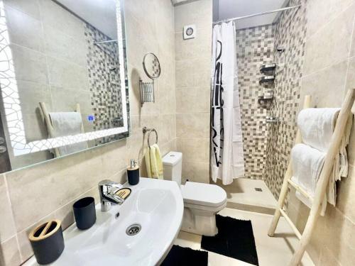 La salle de bains est pourvue d'un lavabo blanc et de toilettes. dans l'établissement Cozy&Elegant apartment/pool/city center/Gueliz, à Marrakech