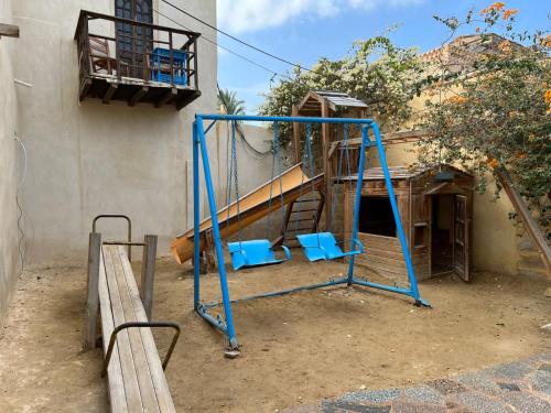 a blue swing set in front of a building at Zad El Mosafer Guest House in Tunis
