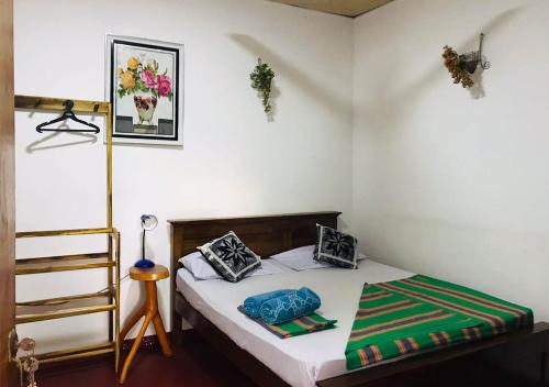Cette petite chambre comprend un lit avec des draps blancs. dans l'établissement Kasun Hotel, à Koslanda