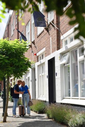 two people standing on a sidewalk near a building at Hotel Bries Den Haag - Scheveningen in The Hague