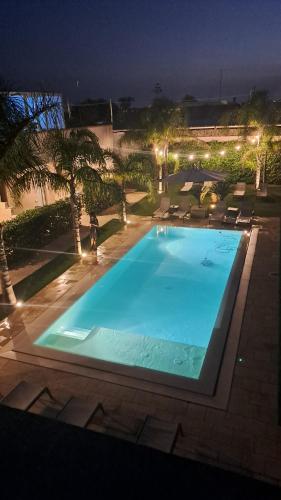una gran piscina por la noche con luces en Le Murge Del Salento Hotel b&b Depandance, en Uggiano la Chiesa