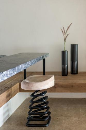 a wooden table with a wooden stool under a counter at Acro Suites - A Wellbeing Resort in Agia Pelagia