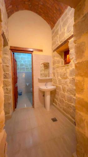 a bathroom with a sink and a stone wall at Zad El Mosafer Guest House in Tunis