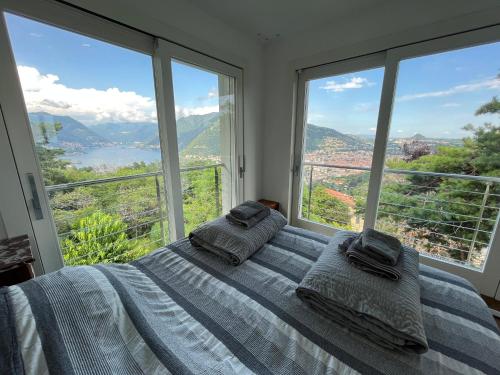 una camera con un letto con due cuscini sopra di Penthouse - Villa Cardano a Como