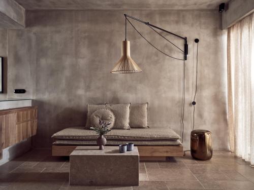 a living room with a couch and a table at Acro Suites - A Wellbeing Resort in Agia Pelagia