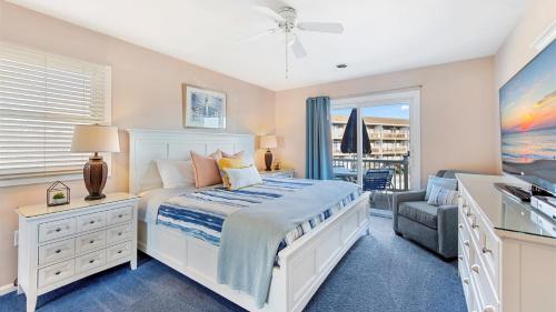 een slaapkamer met een wit bed en een raam bij Lighthouse Point Villas in Ocean City