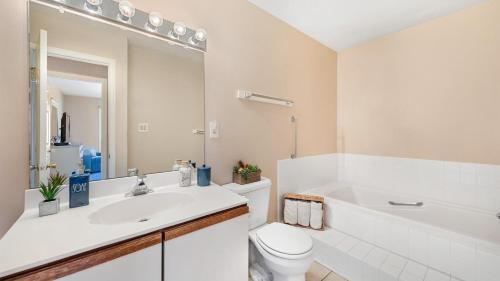a bathroom with a sink and a toilet and a tub at Lighthouse Point Villas in Ocean City