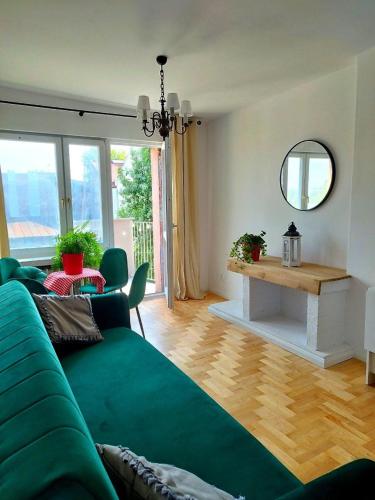 a living room with a green couch and a table at Urban Nest Apartments Starowiślna 30A in Krakow