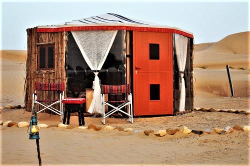 a red tent in the middle of a desert at Legend Desert camp in Fulayj al Mashāʼikh