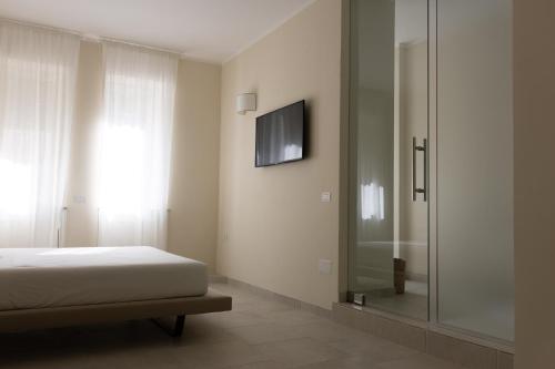 a bedroom with a bed and a glass shower at Oronti Accommodations in Lecce