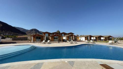 a swimming pool in a resort with mountains in the background at Ananda Beach Camp in Nuweiba‘ el Muzeinah