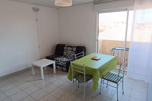 un salon avec une table, des chaises et un canapé dans l'établissement Studio maison de la mer, à Saint Pierre La Mer