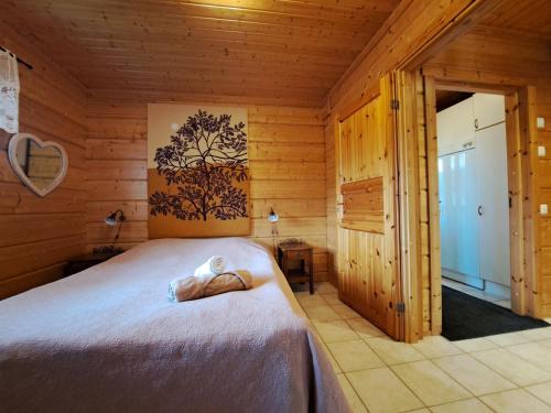 - une chambre avec un lit dans une cabane en bois dans l'établissement Kurkimökki, à Parikkala
