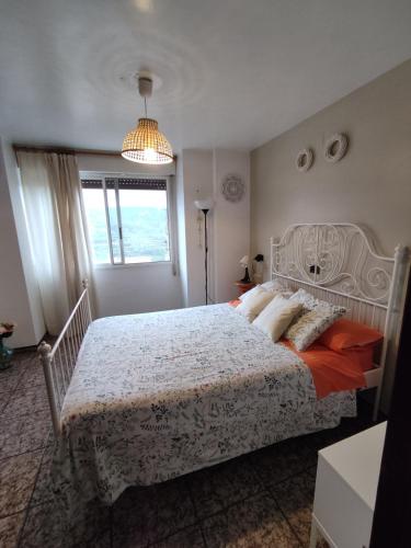 a bedroom with a large bed and a chandelier at Casa Elina I I in Lucena del Cid