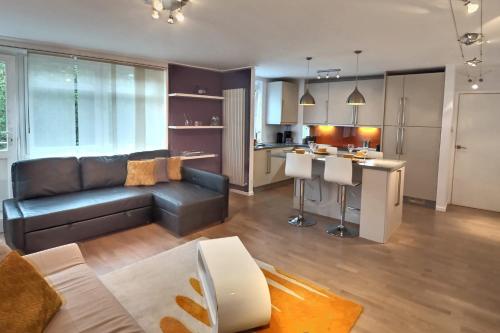 a living room with a couch and a kitchen at Regents Park Area in London