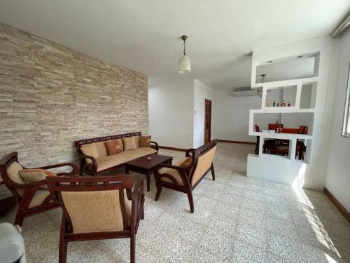 un soggiorno con divano, sedie e muro di mattoni di Departamento en kennedy amplio para familia a Guayaquil