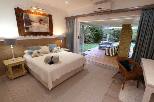 ein Schlafzimmer mit einem großen Bett und einer Terrasse in der Unterkunft Fiddlewood Beach House in Port Shepstone