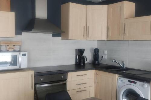 une cuisine avec un évier et une machine à laver dans l'établissement Maison moderne, à Jublains