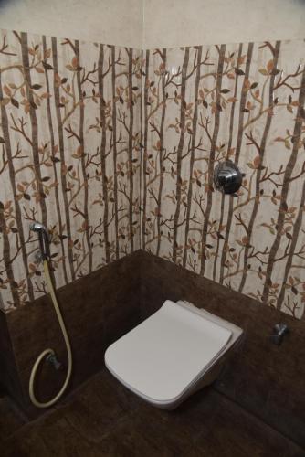 a bathroom with a toilet and a shower at Hotel Girija Sunrise 300 Meter from Baba Dham Temple in Deoghar