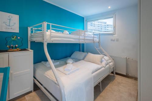 a small bedroom with a bunk bed with a window at CBlue: Küstenzauber barrierefrei mit Balkon in Heiligenhafen