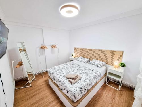 a bedroom with a bed with a wooden headboard at Front Views To El Pilar ComoTuCasa in Zaragoza