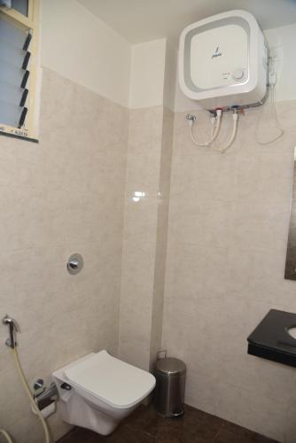 a bathroom with a white toilet and a sink at Hotel Girija Sunrise 300 Meter from Baba Dham Temple in Deoghar