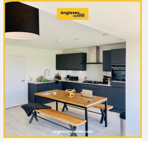 a kitchen with a table with a laptop on it at Anglesey sleeps 10 with hot tub at an additional cost in Llanfaelog