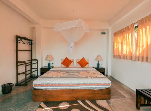 a bedroom with a bed with orange pillows at Hill Safari - Tea Estate Villa in Ohiya