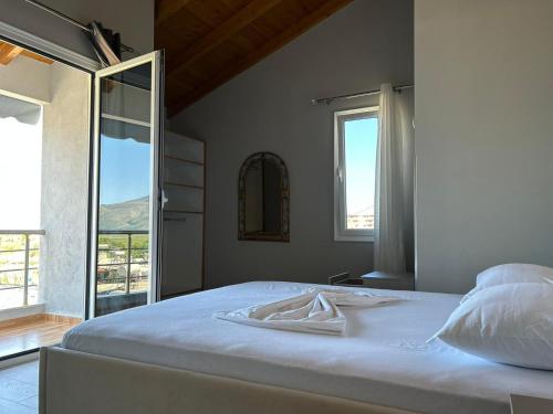sypialnia z dużym białym łóżkiem i oknem w obiekcie Villa Yseni w mieście Orikum