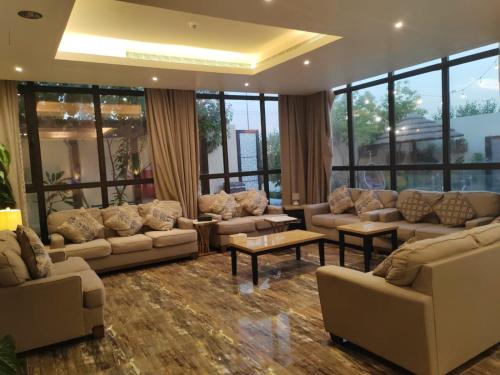 a living room with couches and tables and windows at منتجع ديفان 