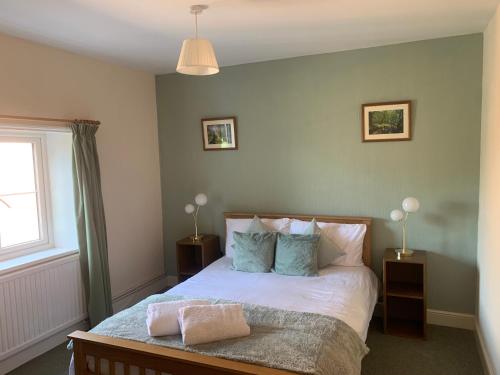 a bedroom with a bed with two lamps and a window at Alby horseshoes inn in Erpingham