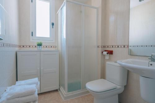 a white bathroom with a toilet and a sink at Vivienda Turística Sunbeach-Xilxes VT-42192-CS in Xilxes
