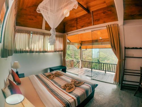 a bedroom with a bed and a balcony at Hill Safari - Tea Estate Villa in Ohiya