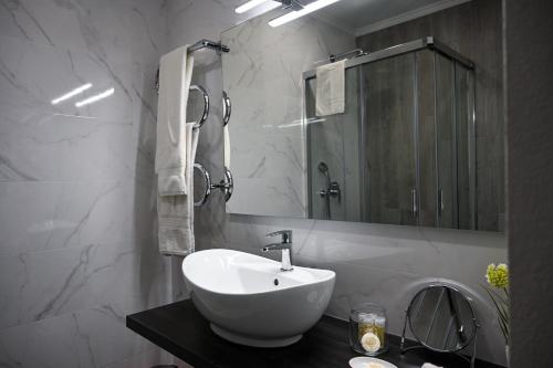 La salle de bains est pourvue d'un lavabo blanc et d'un miroir. dans l'établissement Casa do Briamante 9, à Sintra