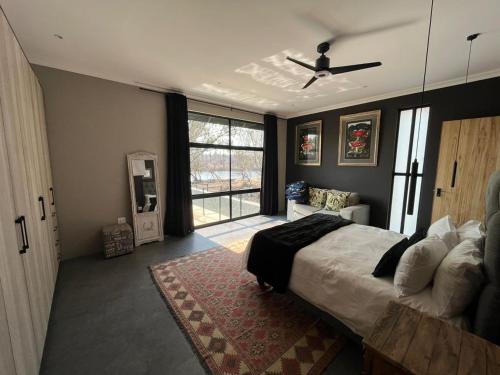 Un dormitorio con una cama y un ventilador de techo. en 236 Vaal de Grace, en Parys