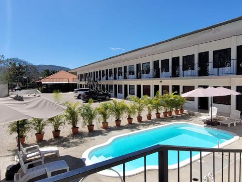 a hotel with a swimming pool in front of a building at HOTEL Y RESTAURANTE RANCHO DE SEBAS in Nicoya