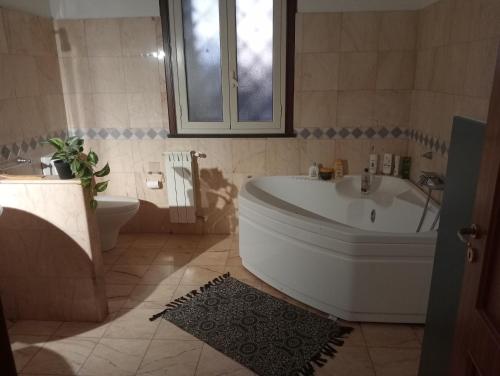 a bathroom with a tub and a sink and a toilet at Milo's House in Mascalucia