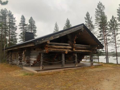 una cabaña de madera en el bosque con techo en Villa Kuiske, en Kuusamo