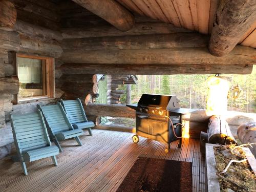 a porch of a cabin with chairs and a stove at Villa Kuiske in Kuusamo