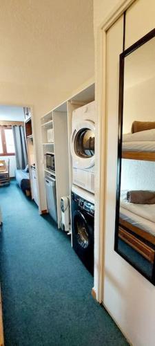 Cette chambre dispose d'un couloir avec deux lits et un miroir. dans l'établissement Studio Tignes Val claret aux pieds des pistes, à Tignes