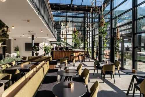 a restaurant with tables and chairs and large windows at Såndgøld Alpine Glamping in Campo Tures