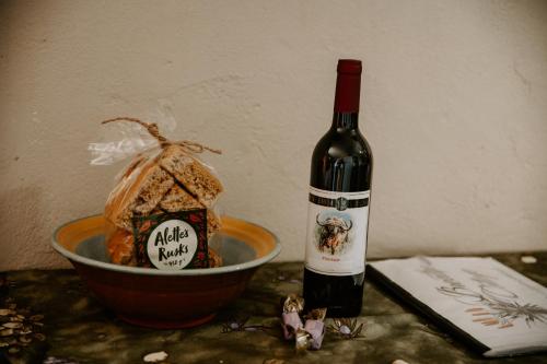 a bottle of wine next to a bowl of food at Breathe Accommodation in Oudtshoorn