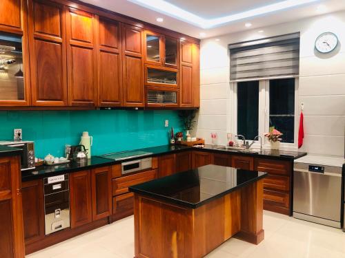 a kitchen with wooden cabinets and a black counter top at Đà Lạt Villa 84 Hồ Xuân Hương in Da Lat