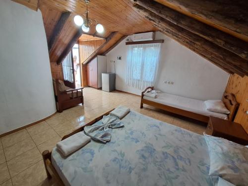Un dormitorio con una cama grande en una habitación con techos de madera. en Guest House Argjiro Castle, en Gjirokastra